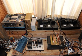 上段左端より、小林の試作DAC２号機、サウンドパーツ製プリ（金色）、DAC電源（灰色）、AD1単段アンプ（黒の２台）<br />下段左端より、テスター（黄色）、デジタルオシロ（青で斜め）、EL34シングルアンプ、フィールド電源